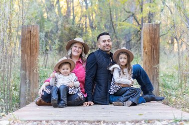 Family portrait taken on a small bridge in the Watson Woods Riparian Reserve in Prescott, Arizona. The girls all wear darling hats.
