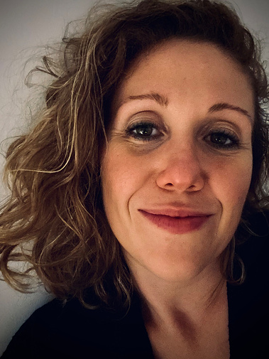 Photo de Clémence Le Prévost Petit, Gestalt-thérapeute. Portrait souriant. Regard pétillant. Cheveux ondulés châtains avec un balayage. 