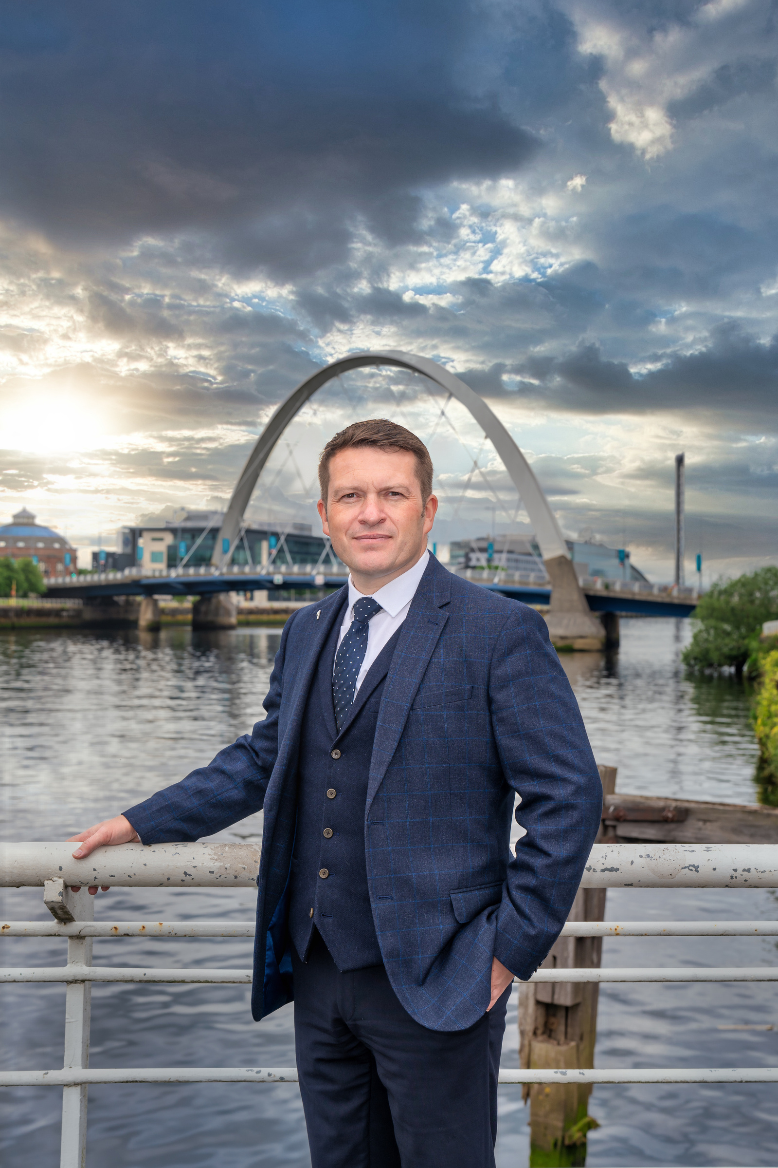 Scotland client posing for headshots on bridge in Glasgow - Photography by Nate Cleary