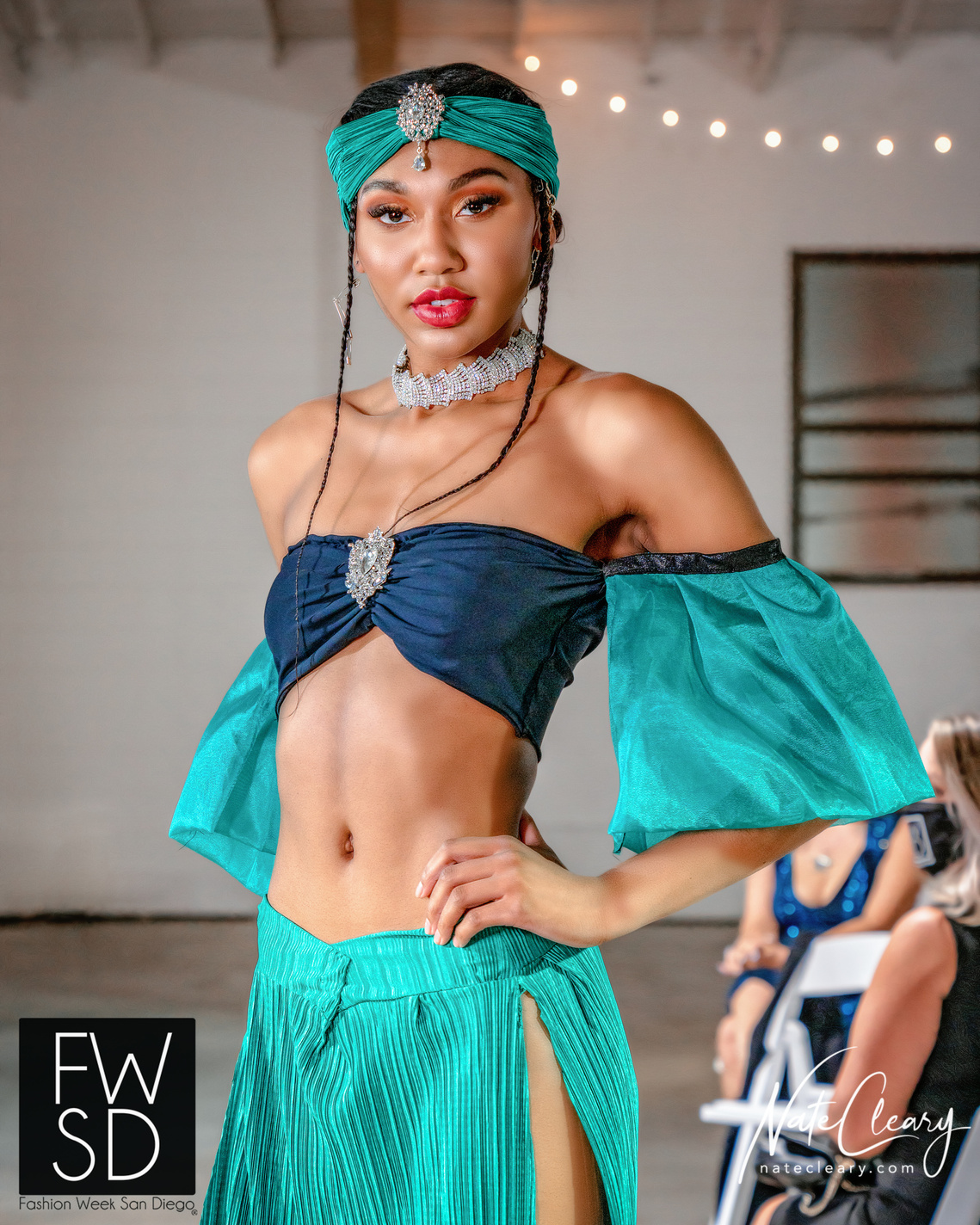 Woman poses on catwalk wearing designer clothing for Fashion Week San Diego