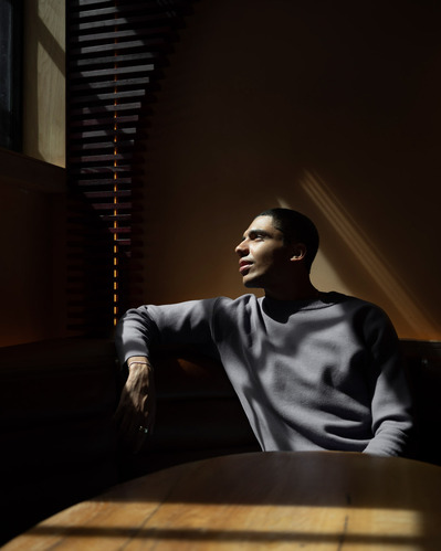 Chiaroscuro portrait of actor Jay Lycurgo lit by  window light in profile.