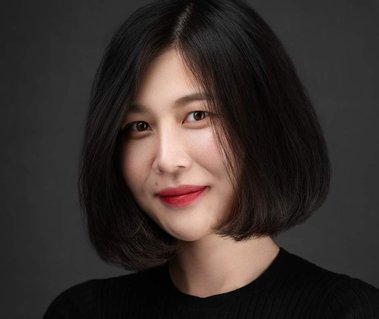 Corporate headshot of a woman with a sleek black bob, wearing a black top against a dark gray background. Ideal for personal branding, actor headshots, business networking, and executive profiles in Arlington Heights and Chicago.