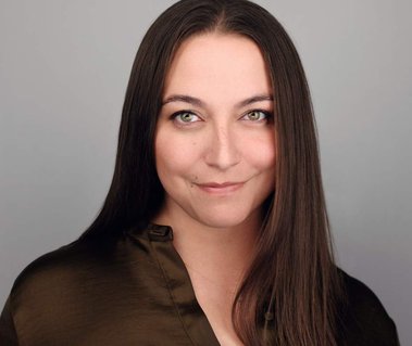 Corporate headshot of a woman with long straight brown hair, wearing an olive-green blouse against a light gray background. Ideal for LinkedIn profiles, actor headshots, creative branding, and professional portraits in Arlington Heights and Chicago.