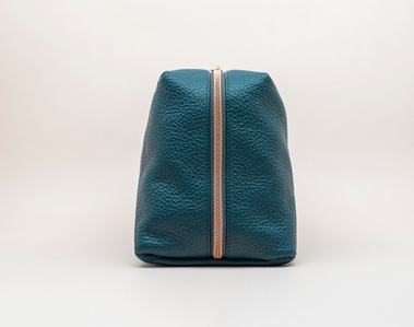 Handcrafted leather cosmetic bag with a unique geometric design. The Stella toiletry bag, made in Delft, Netherlands, features premium pebble grain leather and a rose gold zip. Made to order. Colour: petrol blue