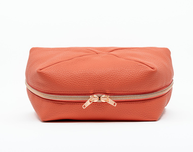Handcrafted coral leather cosmetic bag with a unique geometric design. The Stella toiletry bag, made in Delft, Netherlands, features premium textured leather and a rose gold zip. Available in a made-to-order small-batch production