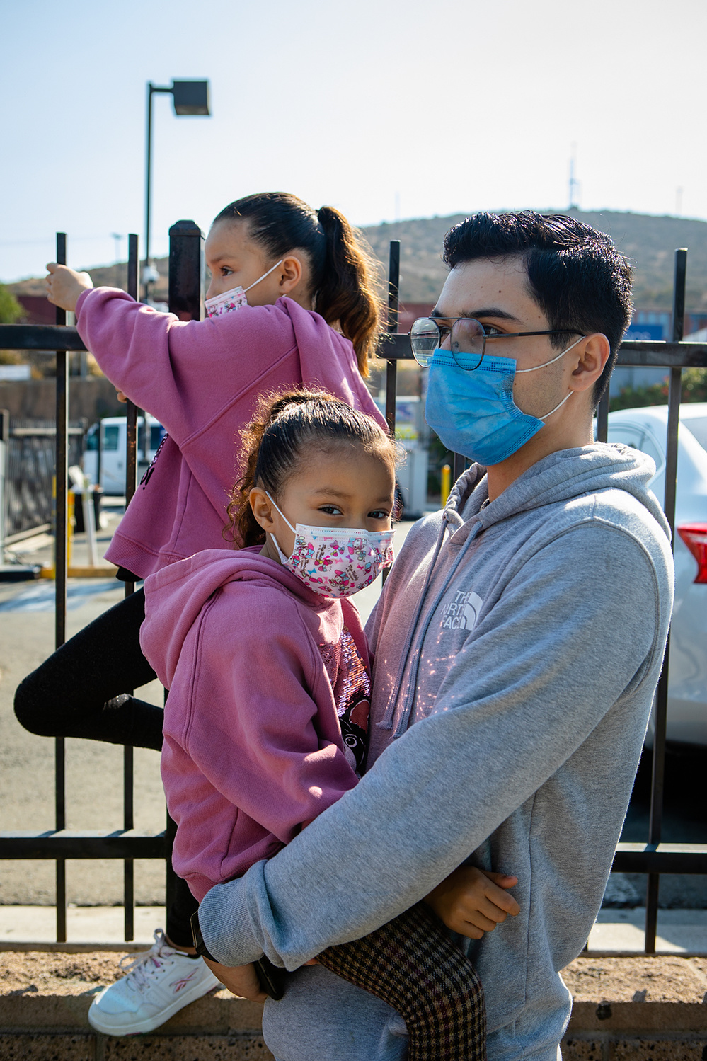 Christopher Olvera waits with his two younger sisters for a ride at the San Ysidro Transit Center, June 14, 2021.