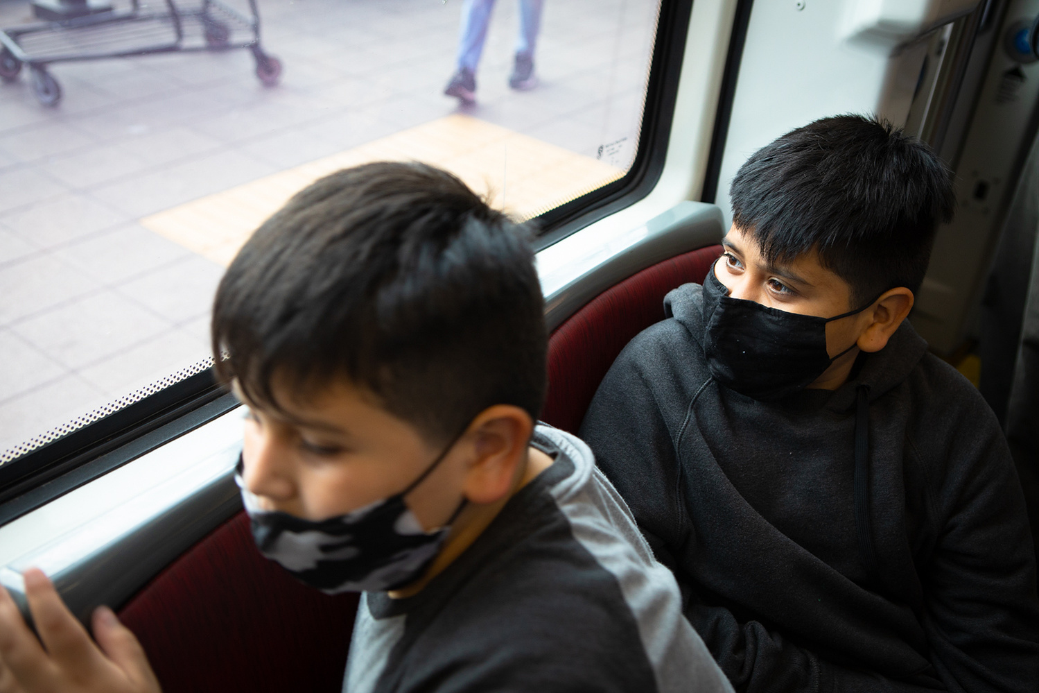 Issac Diaz, right, and his brother, Ulisses Diaz, look out the window of a Blue Line trolley en route to San Ysidro, June 1, 2021.