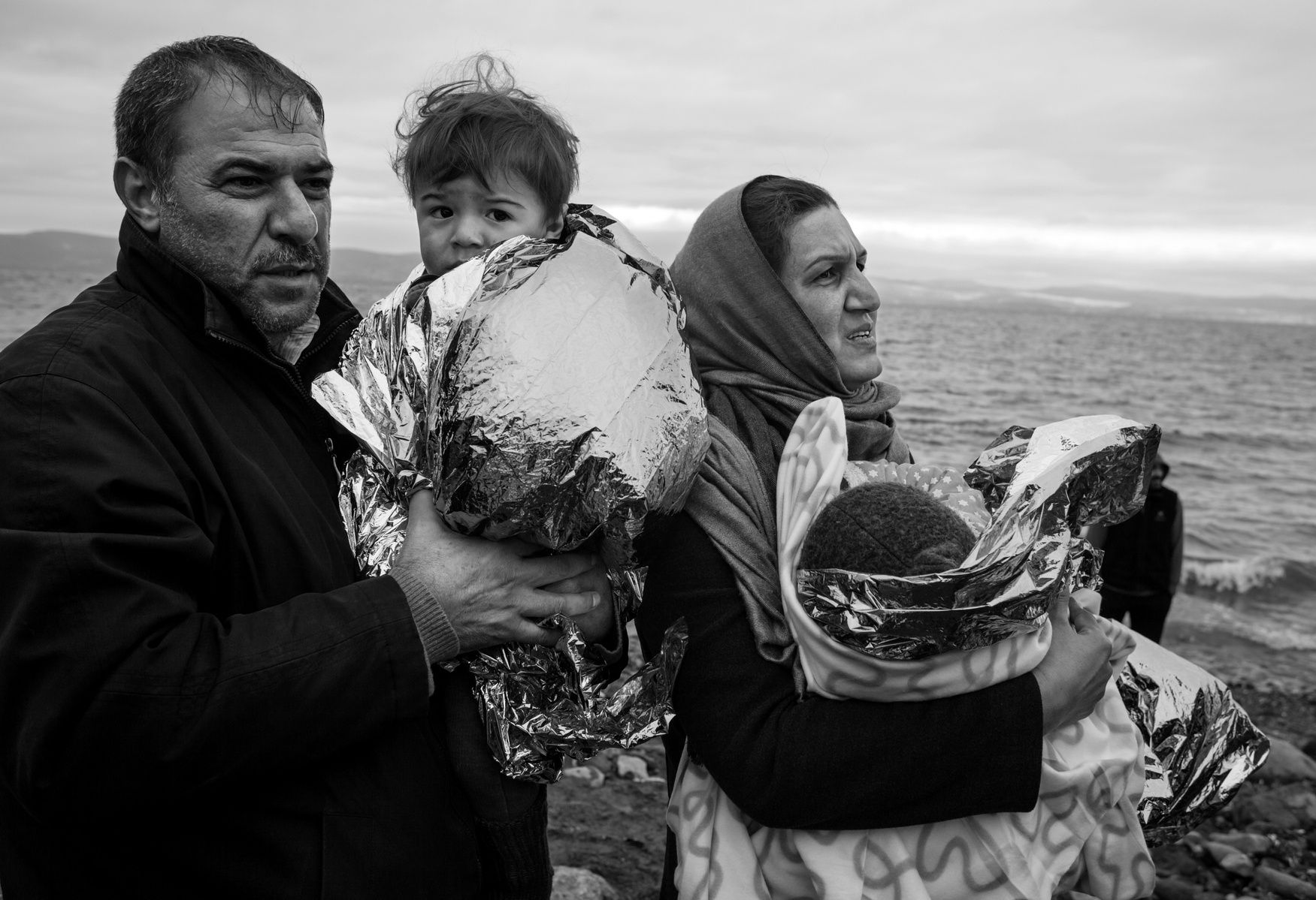 Refugees from Afghanistan and Syria wait for transportation to a transit camp after they landed by rubber boats on the shores of Lesbos near Skala Sikaminias, Greece on 04 January, 2016. Lesbos, the Greek vacation island in the Aegean Sea between Turkey a