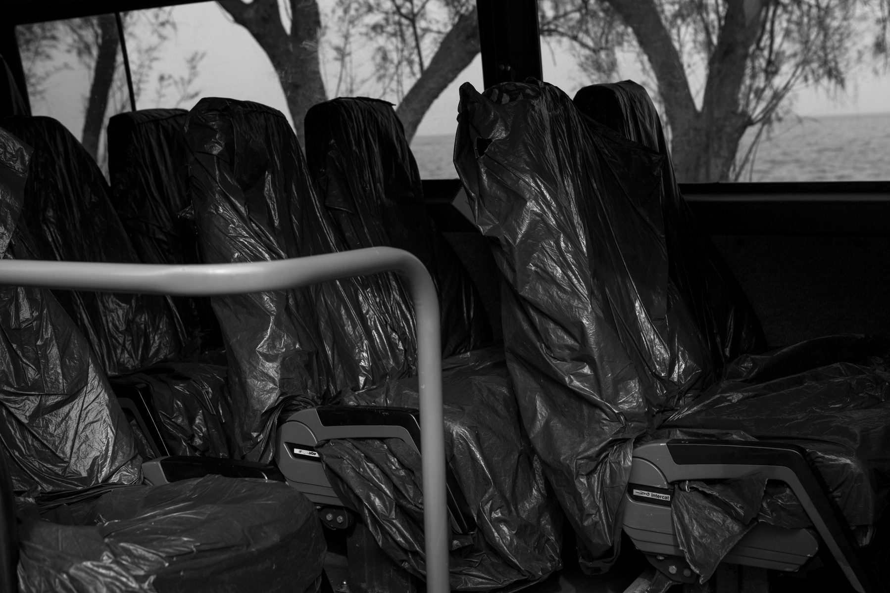 Empty bus with plastic covered seats used to shuttle incoming refugees, some time wet, to registration camps. Refugees from Afghanistan and Syria arrive in boats on the shores of Lesbos near Mytilene, Greece on 02 March, 2016. Lesbos, the Greek vacation i