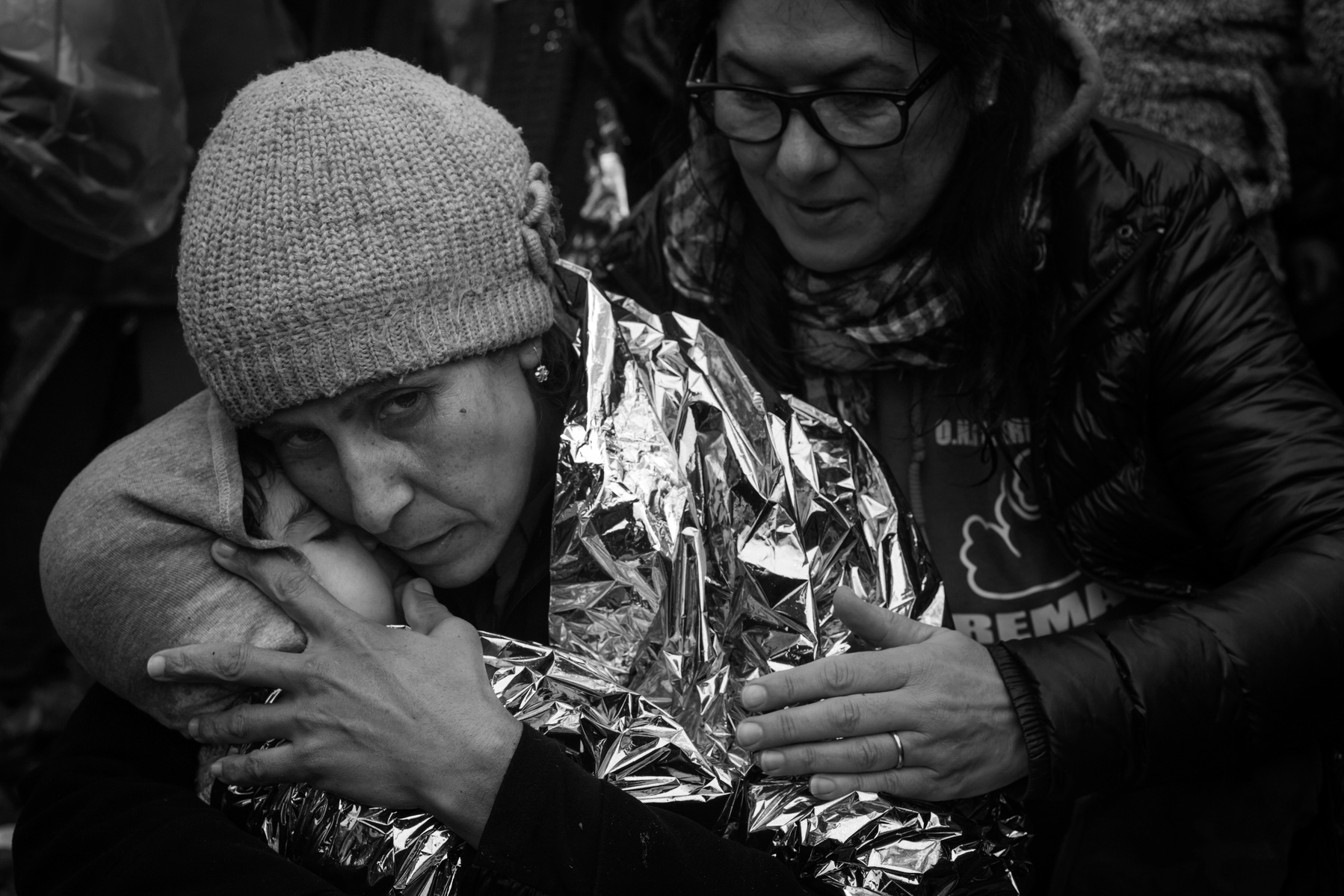 A migrant women hugs her kid while comforted by a volunteer helper on the sea shore. Refugees from Afghanistan and Syria arrive in boats on the shores of Lesbos near Skala Sikaminias, Greece on 05 January, 2016. Lesbos, the Greek vacation island in the Ae