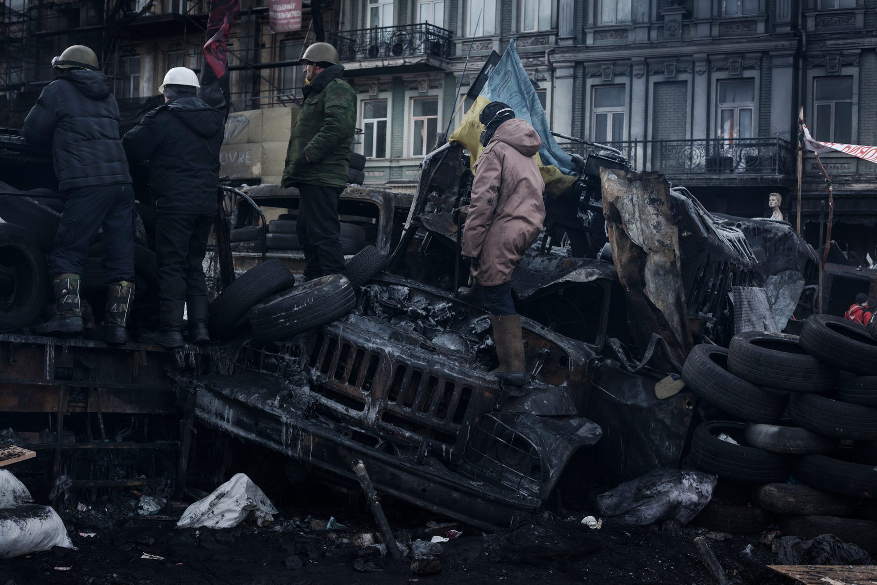 Sitting on pile of tires and charred police bus, anti government protester stands
guard on Hrushevskoho street barricades near Maidan Square during standoff with riot police while a truce was agreed, in Kiev, 27 January 2014.