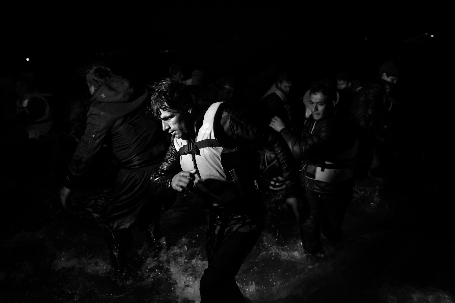 Refugees from Afghanistan and Syria arrive at night on the shores of Lesbos near Skala Sikaminias on a rubber boat with assistance of a fishing boat and the search light of a Greek coast guard vessel. On that night, four bodies of refugees were pulled fro