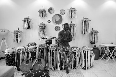 Portrait of Lamine Diedhiou in Dakar, Senegal with Bryan Michael Ham Photography, sitting on a collection of Sabar Drums that are the traditional drums of Senegal.