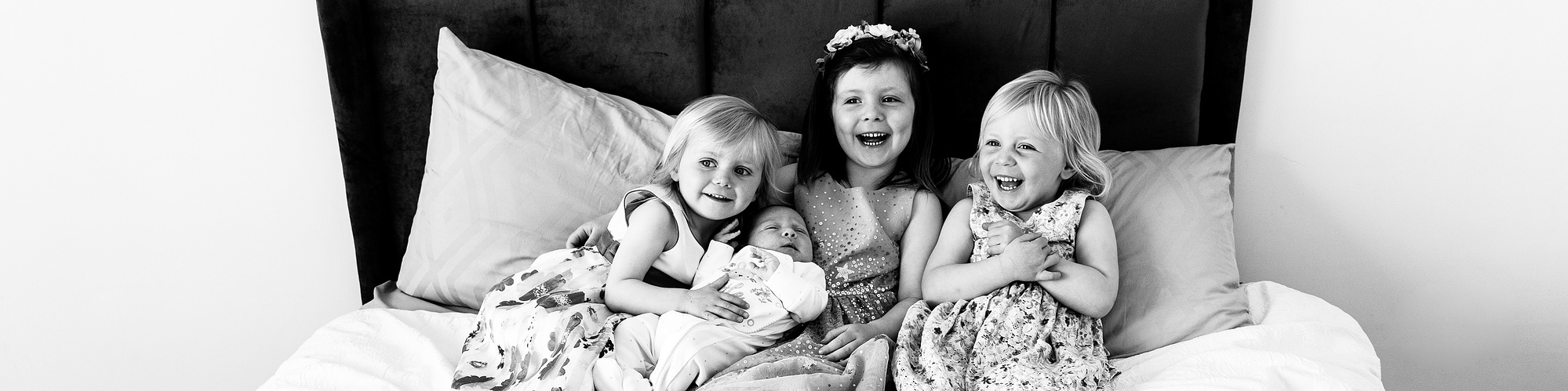 Three sisters giggling in family at home portrait by Kids & Kin professional family photography, Limerick, Ireland