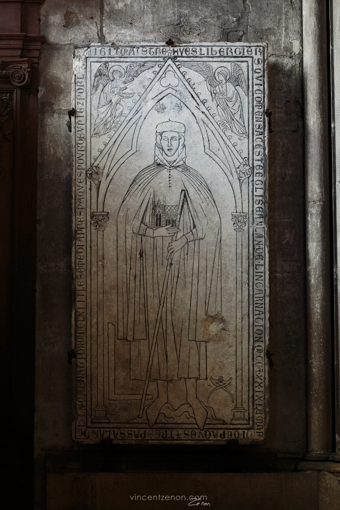 Plate tombe de Hugues Libergier, architecte du XXIIIème siècle, dans son contexte actuel en la cathédrale de Reims, par un jeu de lumière clair-obscur.
