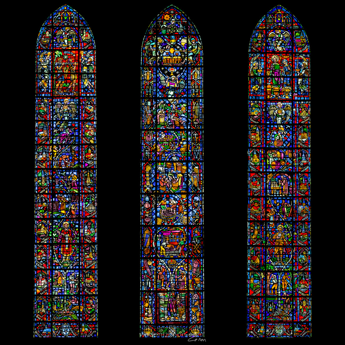 Vitraux du champagne de Notre-Dame de Reims. Offert par la corporation en 1954 et réalisé par l'atelier Jacques Simon. Vue d'ensemble des trois lancettes ogivales sur fond noir d'encre.