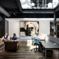 Commercial Architecture Photography of people in an open work space, with artwork of Mark Twain on feature wall