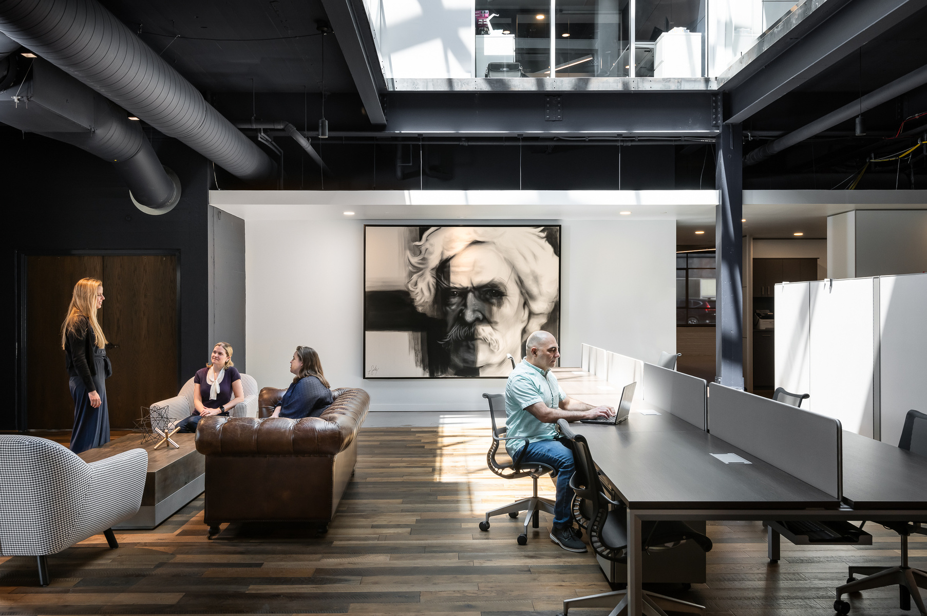 Commercial Architecture Photography of people in an open work space, with artwork of Mark Twain on feature wall