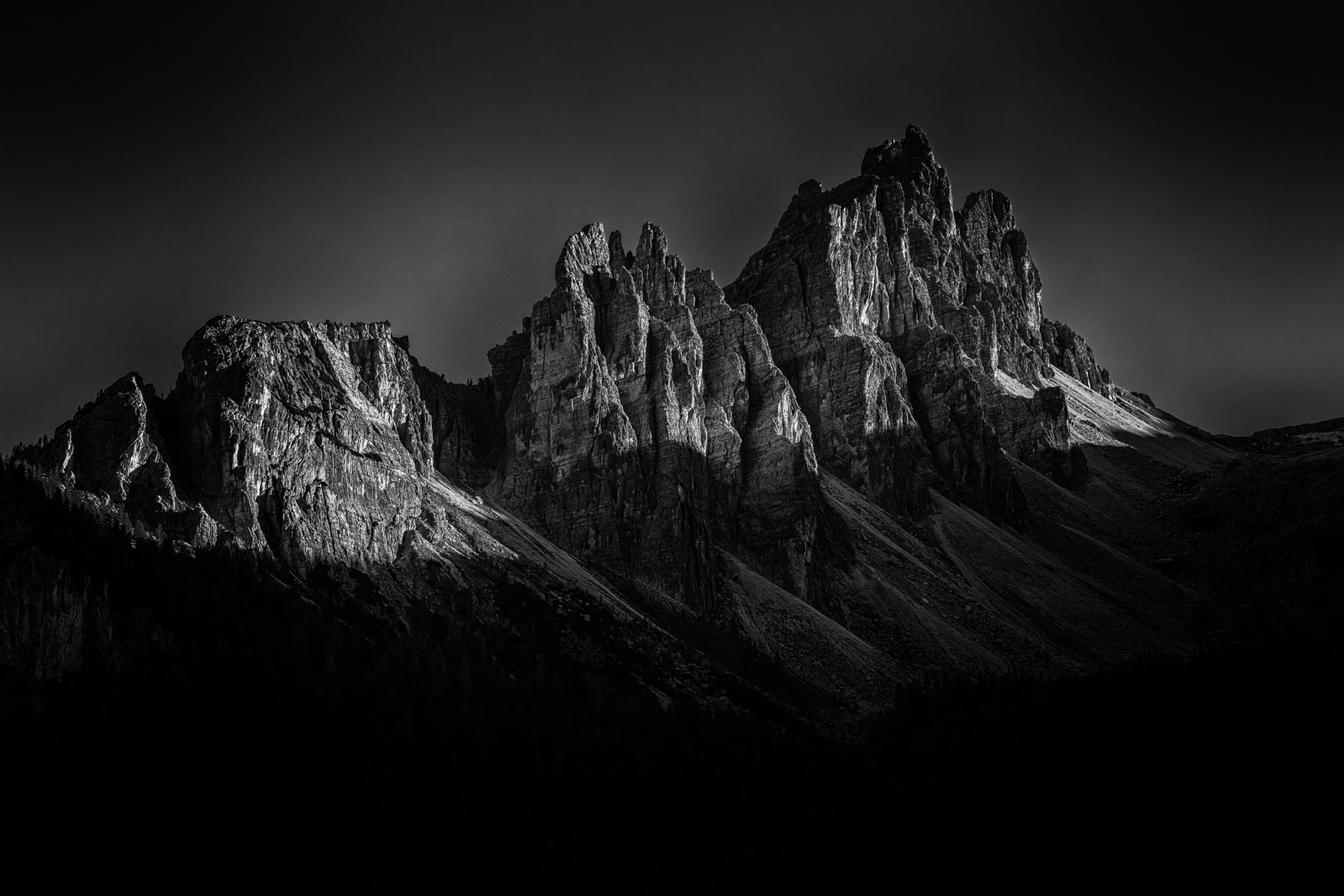 Svart/vit foto av en bergskedja i Dolomiterna / Black and white photo of a mountain range in the Dolomites