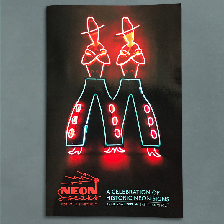 Cover of the Neon Speaks festival program with a neon sign of twin cowboys and the festival logo.