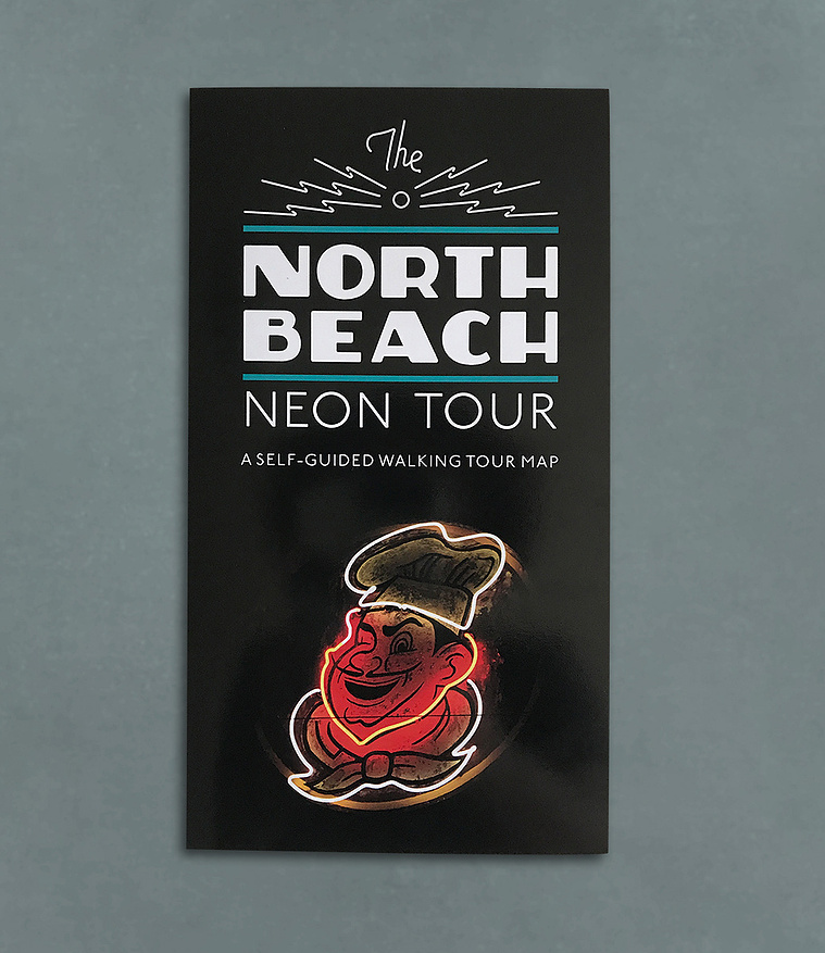 Cover of the North Beach neon tour folded map with a vintage neon sign of a man's smiling face, and wearing a chef's hat and tie.