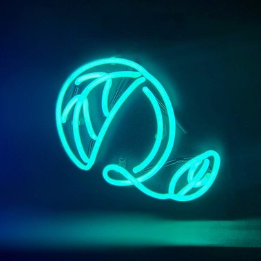 A capital letter “Q” custom designed neon sign in turquoise with a unique, fanciful typographic design.