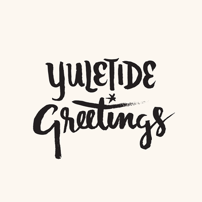 Black and white "Yuletide Greetings" hand lettering design with a brush in black ink, with "Yuletide" in condensed casual capital letters, and "Greetings" in a friendly brush script.