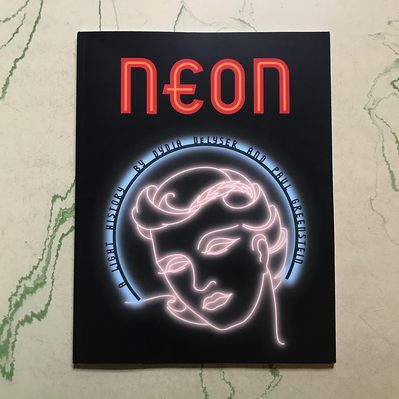 Cover art for “Neon: A Light History” by Dydia DeLyser and Paul Greenstein, with lettering and art based on the original pattern designs for the Earl Carroll Theatre’s fascia neon and channel letters. The sign features a female face in white neon tubing.