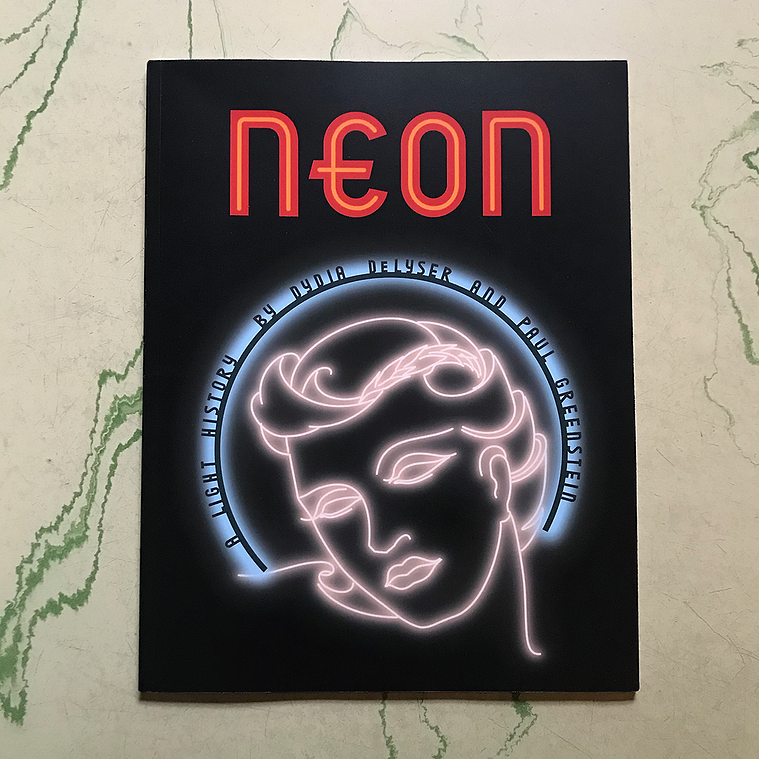Cover art for “Neon: A Light History” by Dydia DeLyser and Paul Greenstein, with lettering and art based on the original pattern designs for the Earl Carroll Theatre’s fascia neon and channel letters. The sign features a female face in white neon tubing.
