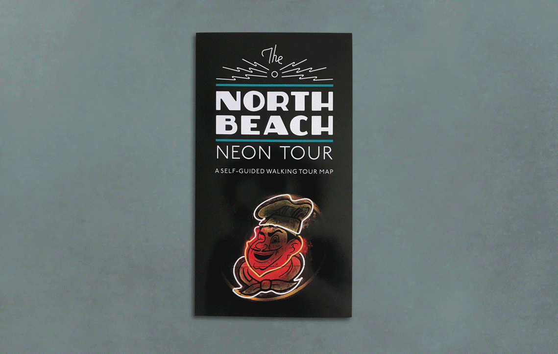 Full layout of the North Beach neon tour folded map with a vintage neon sign of a man's smiling face, and wearing a chef's hat and tie.
