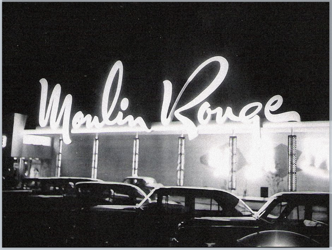 The Moulin Rouge neon sign in upright script lettering, in black and white.