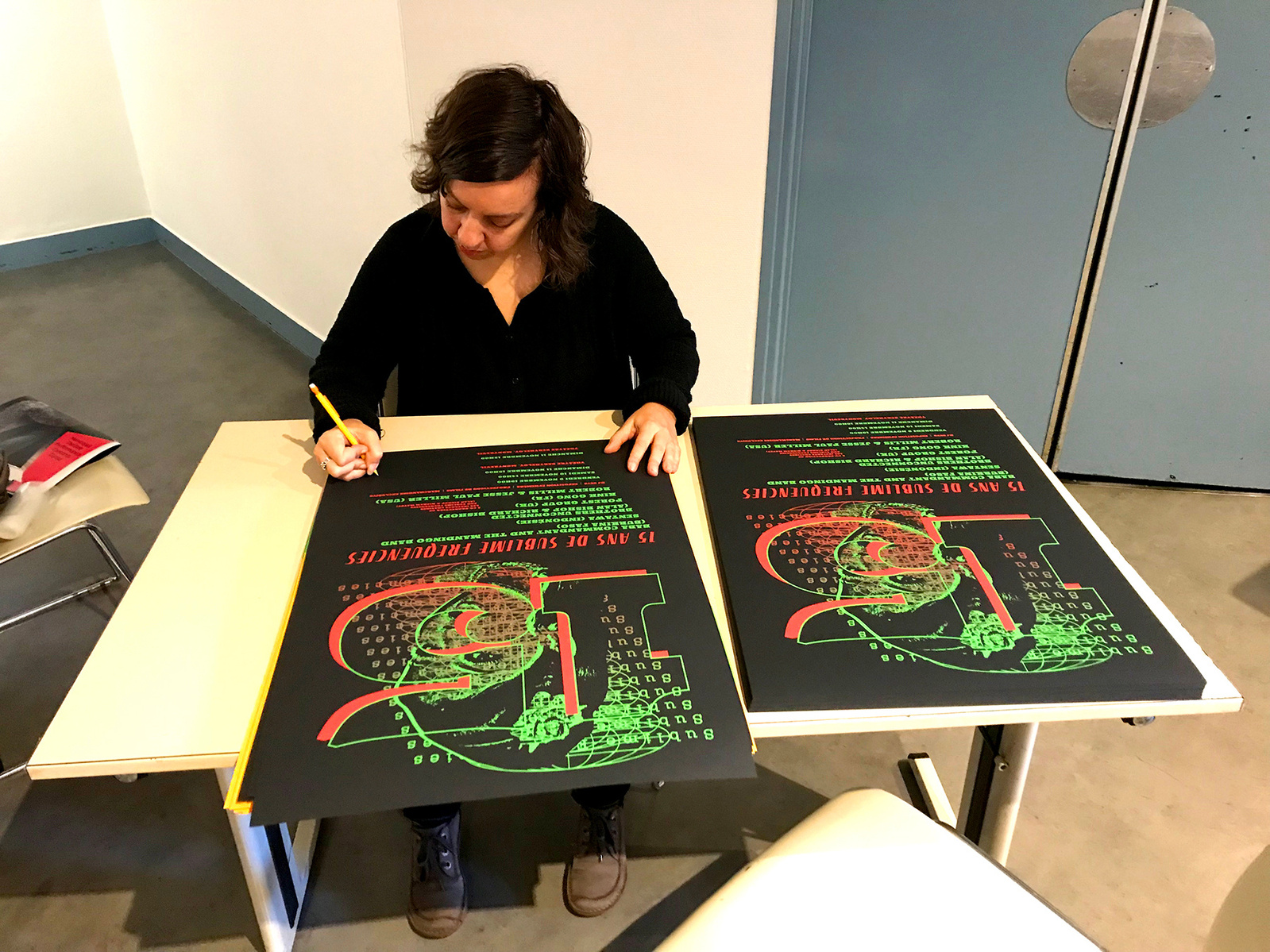 Kate Widdows signing freshly printed letterpress posters she designed for the Sublime Frequencies 15th Anniversary party in Paris.