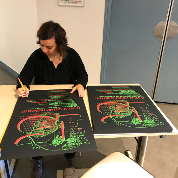 Kate Widdows signing freshly printed letterpress posters she designed for the Sublime Frequencies 15th Anniversary party in Paris.