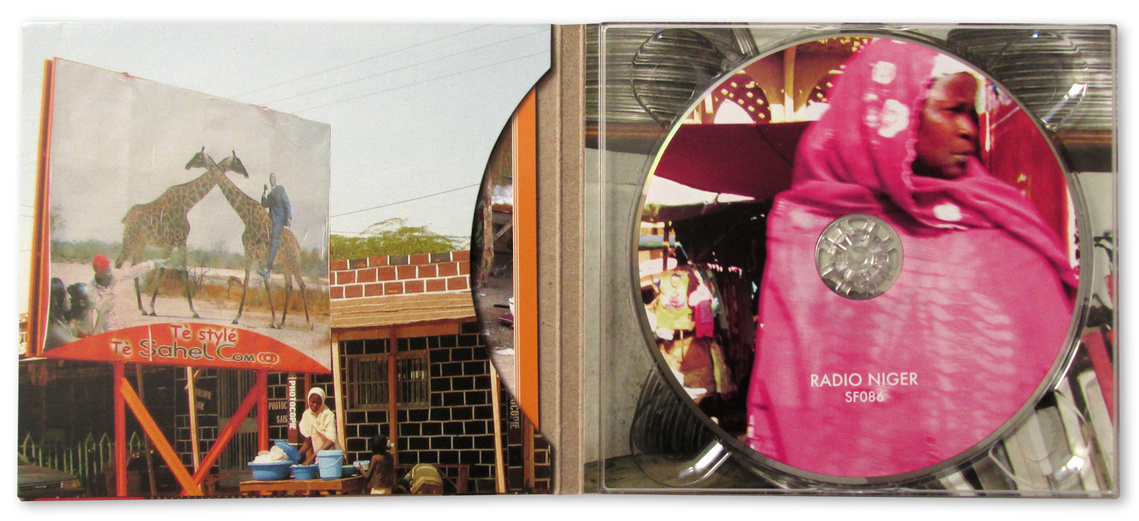 Radio Niger digipak gatefold CD inside spread, featuring a billboard in Agadez with a painting two giraffes on it, and on the CD face a Nigerian woman in a bright pink keffiyeh.