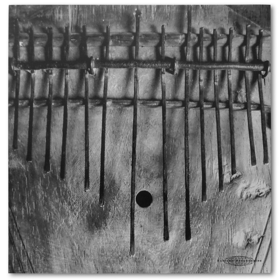 Album back cover art for Music of Tanzania, featuring a closeup of a weathered wood and metal thumb piano in black and white.