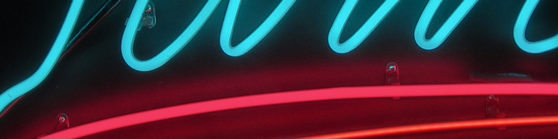 Portion of a neon sign with blue, pink, and red tubes.