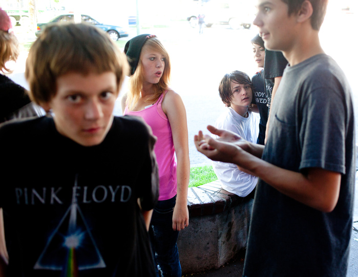 Kyler Kostelec, 15, white shirt sitting and his girlfriend Galina Hensz, 16, second from right, hang out with friends at "the planter" a popular spot for homeless youth to hang out downtown on Tuesday, August 27, 2013, in front of the Olive Garden on West