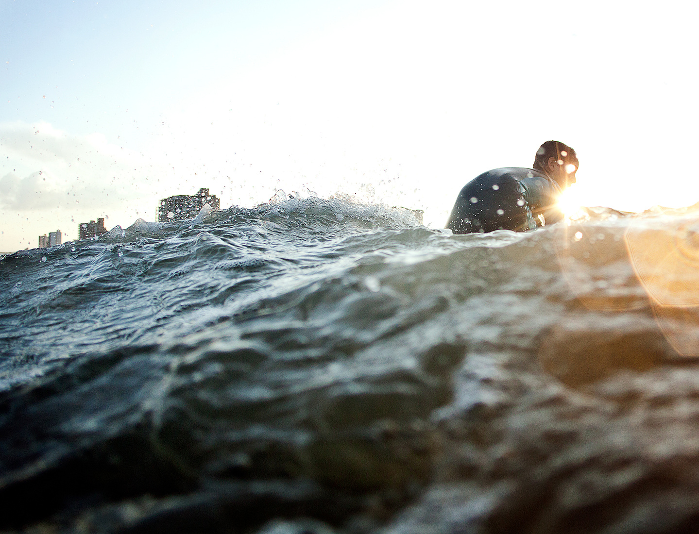 guy in wetsuit surfing a wave in myrtle beach south carolina at sunset