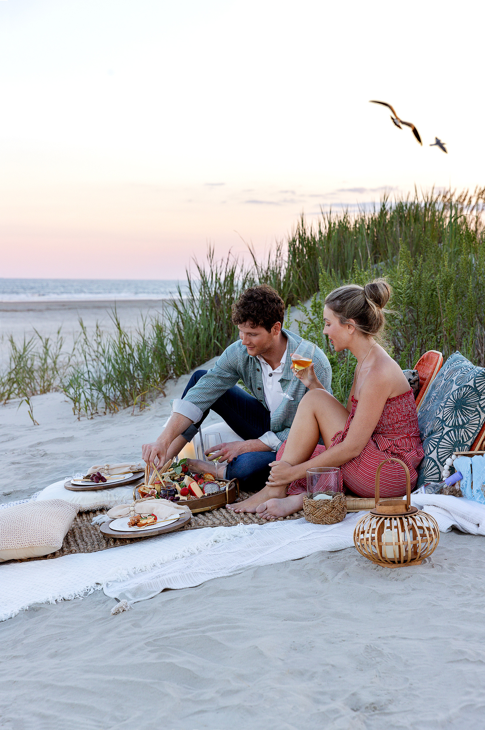 A young couple enjoying a beach picnic at sunset in Myrtle Beach.