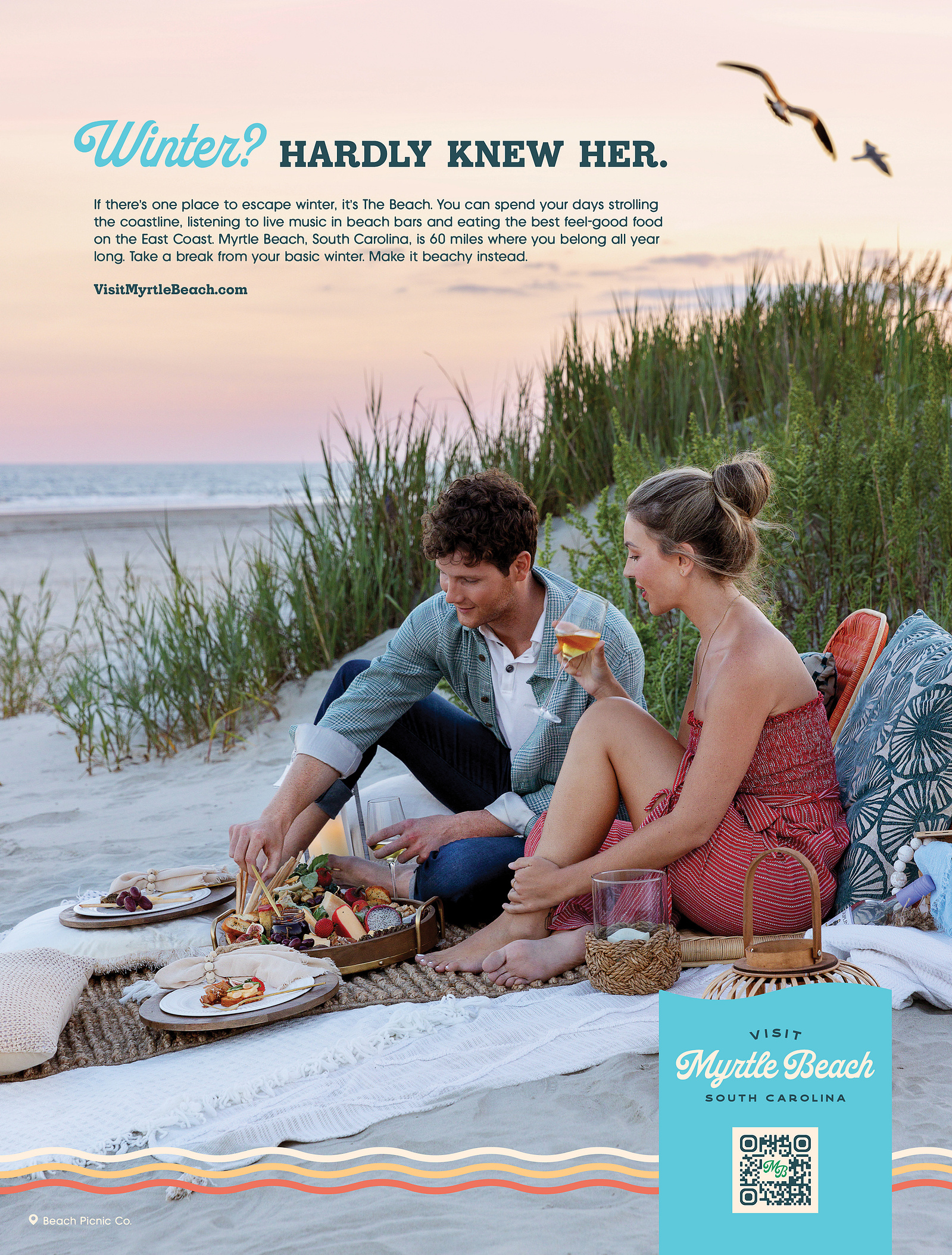 full page advertisement for Visit Myrtle Beach of a couple enjoying a beach picnic at sunset.