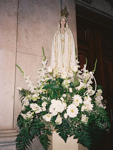 Statuette of the Virgin Mary and a bouquet of white flowers in a church in Lisbon.
Statuette de la Vierge Marie et un bouquet de fleurs blanches dans une église de Lisbonne.