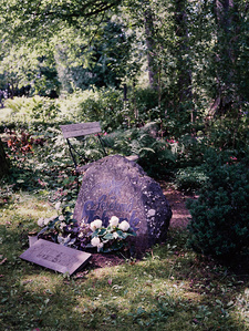 A tomb in a traditional Estonian cemetery, surrounded by trees and vegetation.
Une tombe dans un cimetière traditionnel estonien, au milieu des arbres et de la végétation.