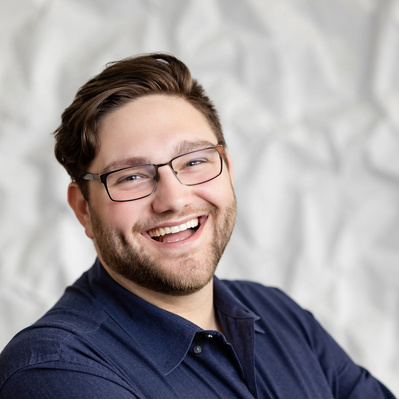 A Corporate headshot of a smiling white man with short brown hair, a beard, wearing black glasses, and a gray long-sleeved shirt.
http://www.annanproductions.com/