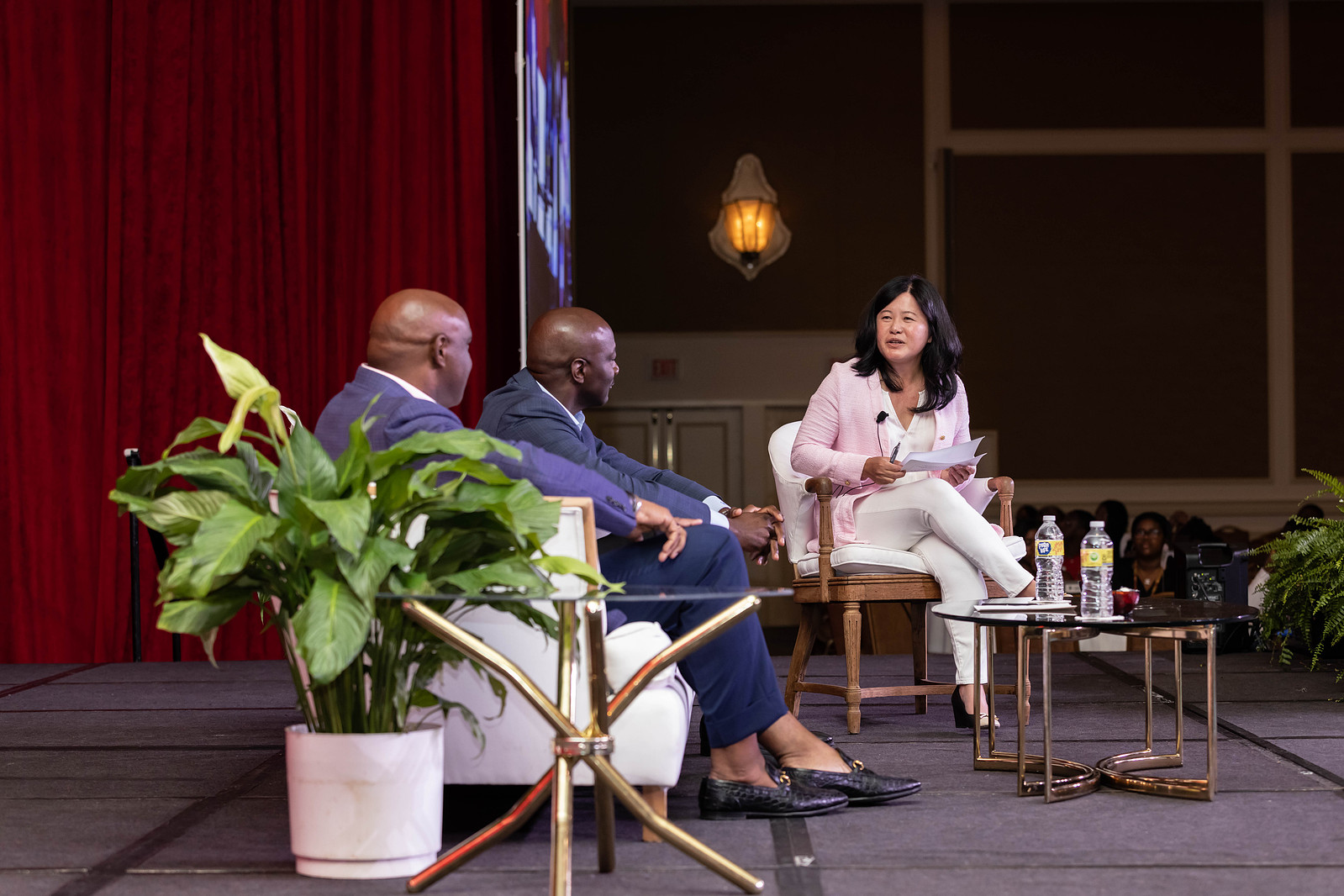 A sit-down interview between an Asian woman wearing a pink blazer and white pants and two bald black men wearing blue suits at the 16th Annual Conference of African American Financial Professionals - CAAFP Event 2022
https://www.annanproductions.com