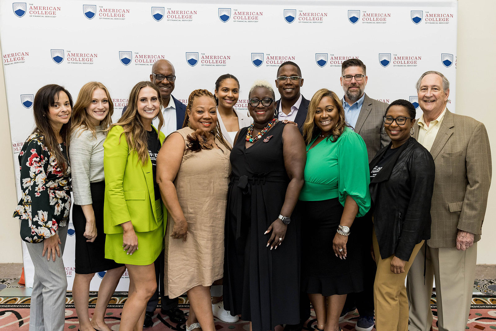 A diverse group of individuals is smiling and posing at a photo booth session during the American College of Financial Services Event.
https://www.annanproductions.com/