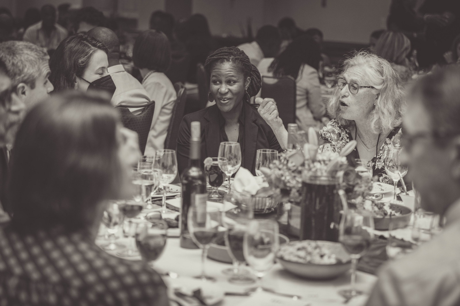 Women gathered at a table eating, drinking, and smiling at the 5th Haiti Funders Conference in Washington D.C.