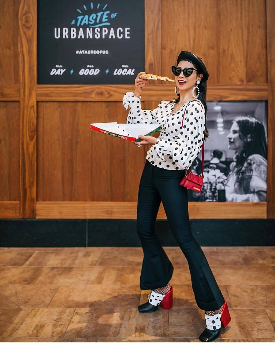 Influencer eating pizza at indoor foodhall