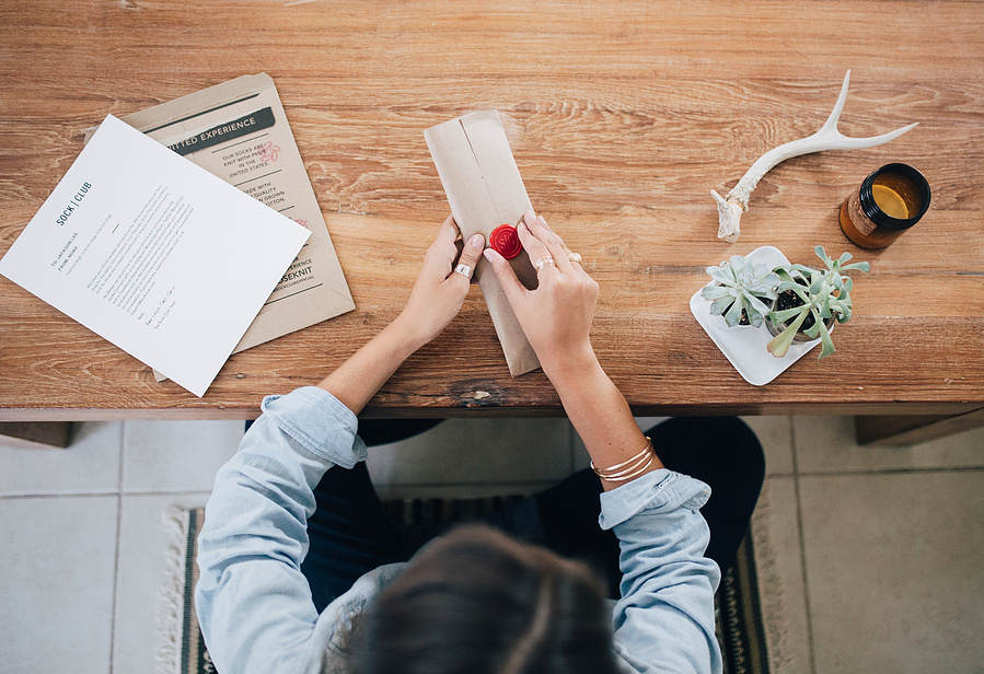 Woman sitting at desk opening gift brand
