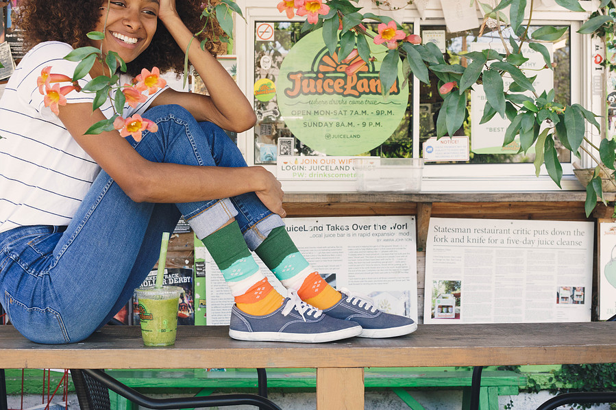 Custom sock designs modeled on woman sitting at juice bar