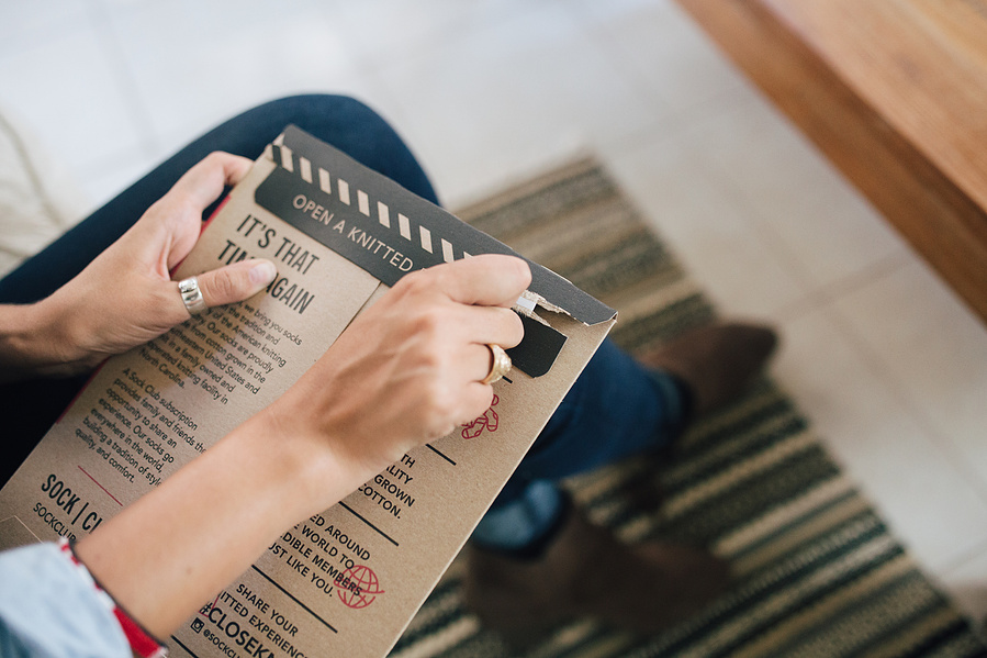 Person opening apparel subscription packaging brand